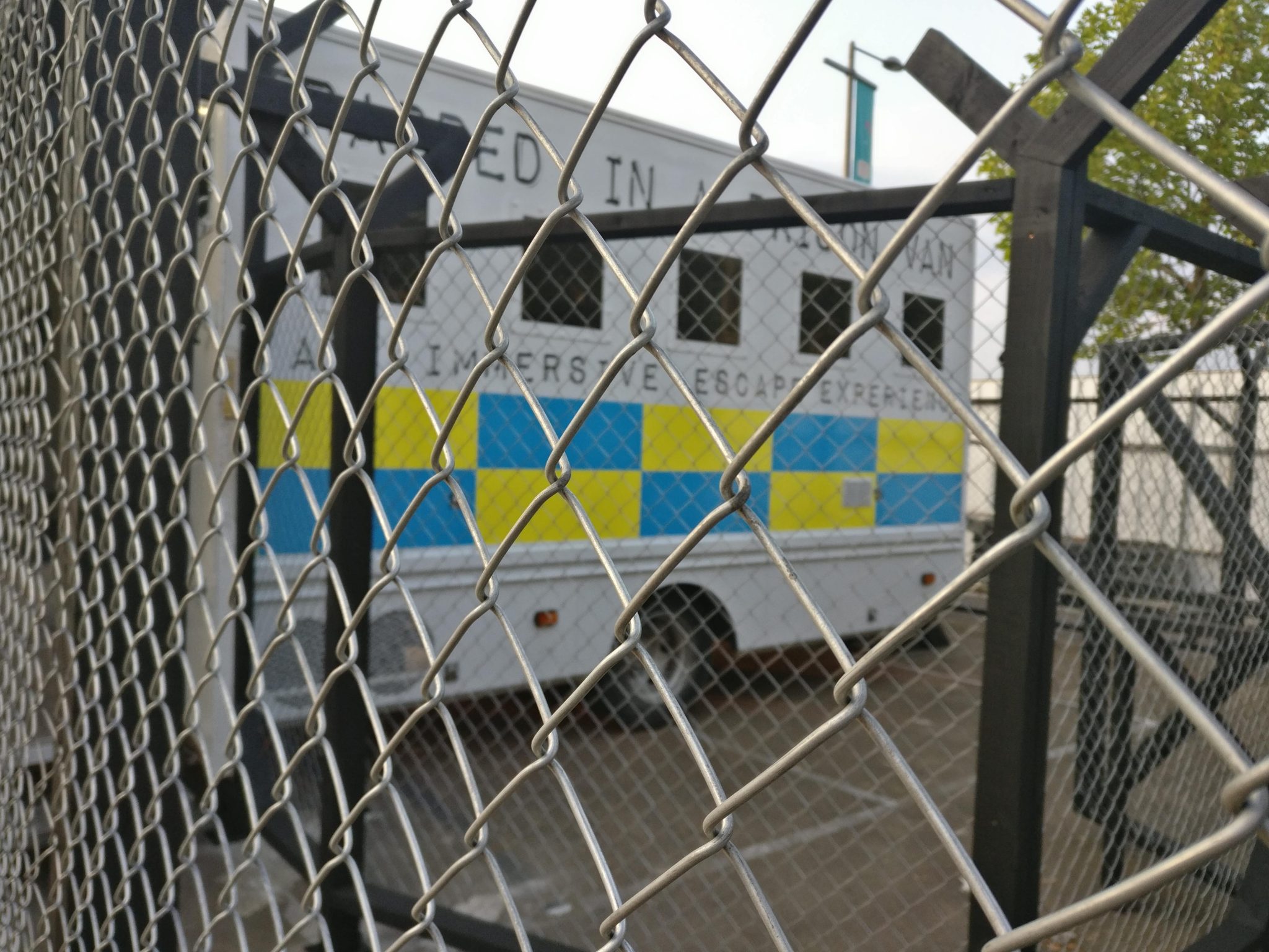 The prison van behind the chain-link fence